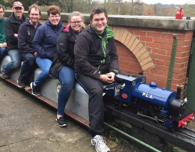 Several smiling society members on a train. Click here to open a new eMail
